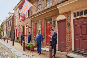 The four attorneys stand in front of a row of townhouses