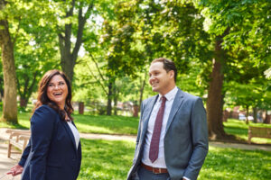 Attorneys Kristin Buddle and Tyler Stampone smile in the park.