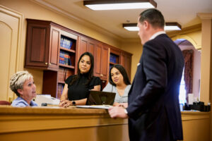 Team members stand at reception desk and talk